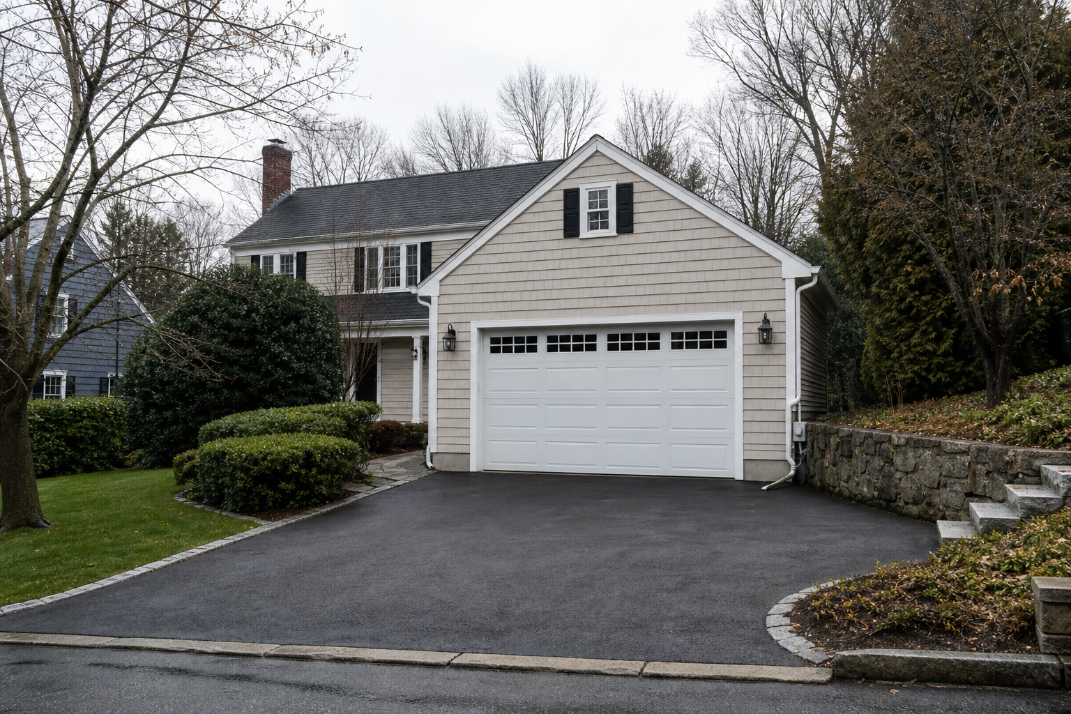 Brookline home exterior with a closed garage door on a quiet driveway